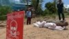 FILE - A Cambodian Mine Action Center (CMAC) member (L) and policeman keep watch behind a Mark 82 bomb in Kandal province on May 21, 2015. 
