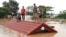 Villagers take refuge on a rooftop above flood waters from a collapsed dam in the Attapeu district of southeastern Laos, July 24, 2018. 