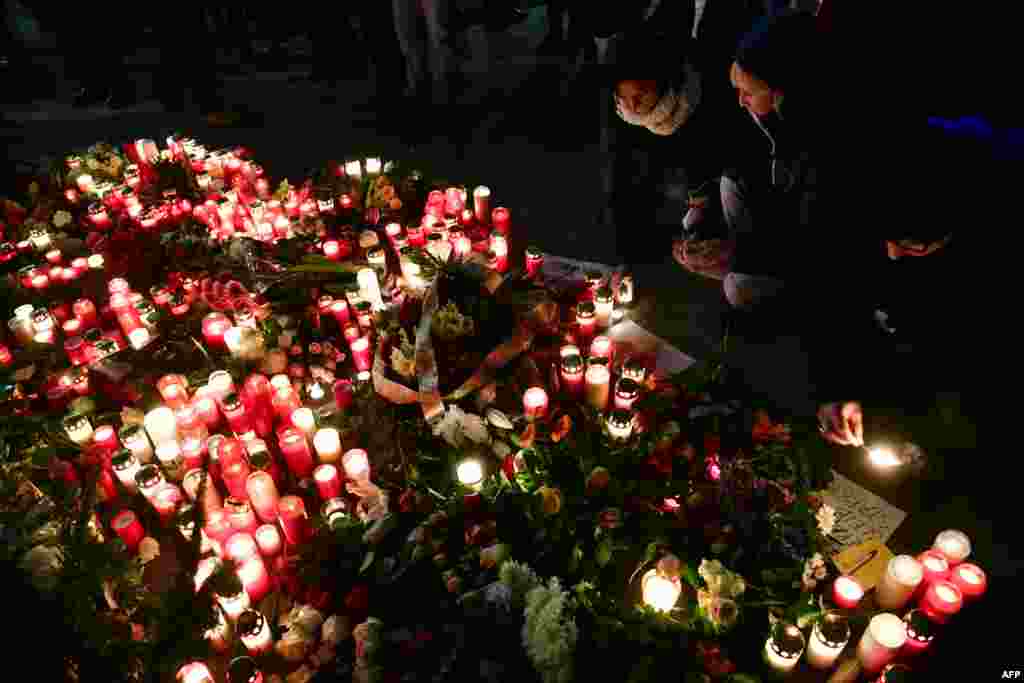 People light candles at a makeshift memorial, Dec. 20, 2016, in front of the Kaiser-Wilhelm-Gedaechtniskirche (Kaiser Wilhelm Memorial Church) in Berlin, where a truck crashed the day before into a Christmas market. Twelve people were killed and almost 50 wounded, when the truck tore through the crowd, smashing wooden stalls and crushing victims.