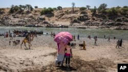 Wakimbizi waliokimbia vita jimbo la Tigray wakiwasili kwenye eneo la Mto Tekeze katika mpaka wa Sudan-Ethiopia, Hamdayet, mashariki ya Sudan. (AP Photo/Nariman El-Mofty, File)