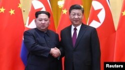 中共中央总书记、国家主席习近平和朝鲜劳动党委员长、国务委员会委员长金正恩在北京人民大会堂握手（2018年3月28日发布的照片）