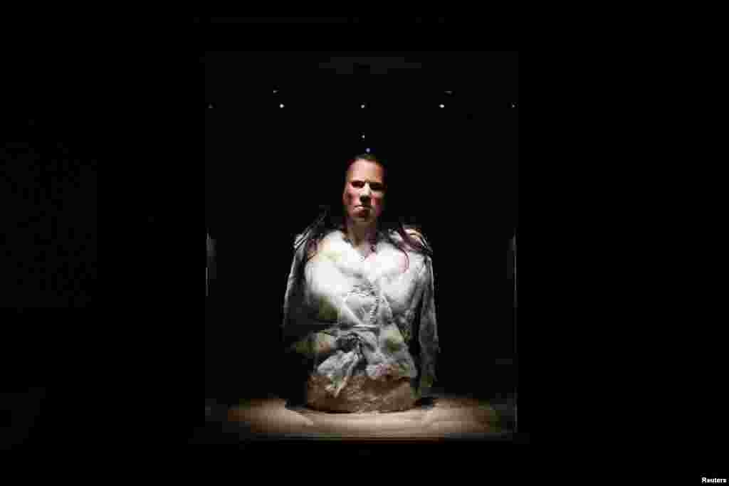 The reconstructed face of 'Dawn,' a young woman who lived about 7,000 BC in a cave in Greece, is displayed during a presentation at the Acropolis museum in Athens, Greece. A Greek team led by an orthodontics professor has reconstructed the face of 'Dawn', from her remains, bringing to life a person who lived during the mesolithic period, and uncovering details of her everyday existence.