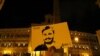 FILE - A man holds a placard during a vigil in memory of Giulio Regeni, who was found murdered in Cairo, Egypt, in January of 2016, in downtown Rome, Italy, Jan. 25, 2017.