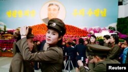 14일 북한 김일성 주석의 102번째 생일을 맞아 여군들이 평양 시내에 마련된 김일성화 전시장 앞에서 사진을 찍고 있다.