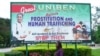 A student at Nigeria's Benin University in Benin City walks past a billboard encouraging women to fight prostitution and human trafficking.