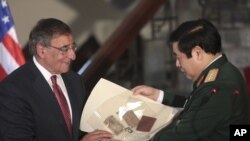 美国国防部长帕内塔在越南国防部把美方保留的一名越南士兵的战争遗物交给越南国防部长冯光青。