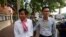 In this photo taken on Oct. 3, 2019, journalists Uon Chhin, left, and Yeang Sothearin arrive at the municipal court, in Phnom Penh. A Cambodian court has ordered a new investigation and postponed a verdict in the espionage trial of the two journalists.