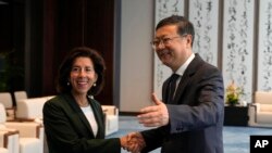 上海市委书记陈吉宁在与来访的美国商务部长雷蒙多会谈前与她握手。（美联社）