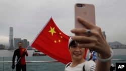 FILE - Pro-China supporters take a selfie with a Chinese national flag during a rally in Hong Kong, Aug. 17, 2019. Twitter has suspended accounts that it believes were part of a Chinese government campaign targeting the protest movement in Hong Kong.