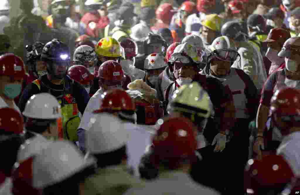 Rescue workers carry an injured survivor after an explosion in a building at Mexico's state-owned oil company PEMEX complex, in Mexico City, January 31, 2013.