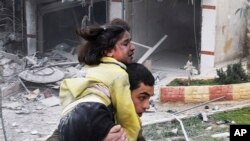 3일 시리아 알레포 지역에 정부군의 폭격 후, 부상당한 동생을 실어나르는 청년.