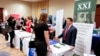 FILE - Corporate representatives speak with job seekers at a job fair in Pittsburgh, Pennsylvania, March 30, 2016. 