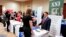 FILE - Corporate representatives speak with job seekers at a job fair in Pittsburgh, Pennsylvania, March 30, 2016. 