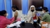 Health workers administer COVID-19 vaccine to women at a vaccination center in Mumbai, India, Friday, Jan. 7, 2022. 