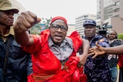 FILE - A protester is arrested by police during a demonstration to protest a controversial tax on the use of social media, Kampala, Uganda, July 11, 2018.