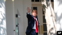 美国总统特朗普2018年10月1日在白宫玫瑰园附近的柱廊向媒体记者挥手致意。