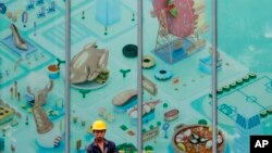 중국 베징에 새로 문열 연 쇼핑몰 지도 앞에 건설노동자가 서 있다. (자료사진)