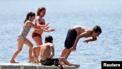 미국 미네소타주 미니애폴리스의 칼훈 호수에서 아이들이 물놀이를 하고 있다.