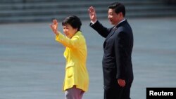 Presiden Korea Selatan Park Geun-Hye (kiri) dan mitranya dari China Presiden Xi Jinping melambaikan tangannya dalam lawatan Presiden Park Geun-Hye di Beijing, (27/6/2013). 