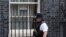 A police officer walks past a drawing of a rainbow with the words "we are in this together" displayed in one of the windows of 10 Downing Street in London, April 9, 2020. 