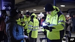 4일 덴마크 코펜하겐 국제공항의 기차역에서 직원들이 스웨덴에 입국하는 여행객들의 신분증을 검사하고 있다. 