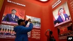 2018年11月15日，北京中国国家博物馆举办中国改革开放40周年展览突出习近平主席，参观者用手机拍照。