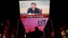 Seorang pria mengendarai skuter melewati layar raksasa yang menayangkan cuplikan berita Presiden China Xi Jinping yang menghadiri pertemuan politbiro Partai Komunis China, di Beijing, China, 9 Desember 2024. (Tingshu Wang/REUTERS)
