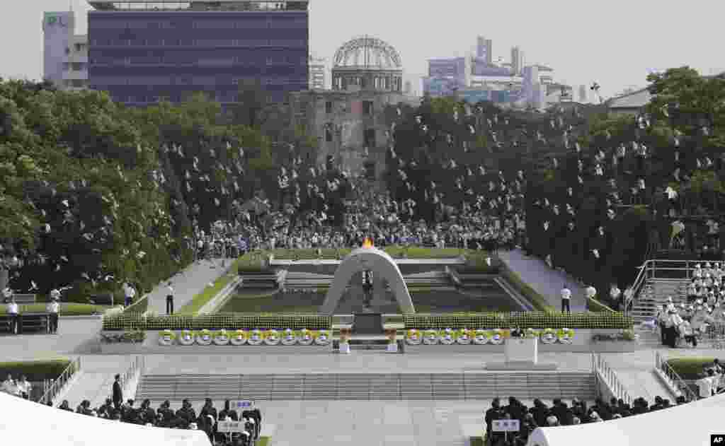 Merpati terbang di monumen yang dipersembahkan untuk para korban pengeboman di Hiroshima Peace Memorial Park dalam upacara peringatan 68 tahun serangan itu (6/8).&nbsp;(AP/Shizuo Kambayashi)