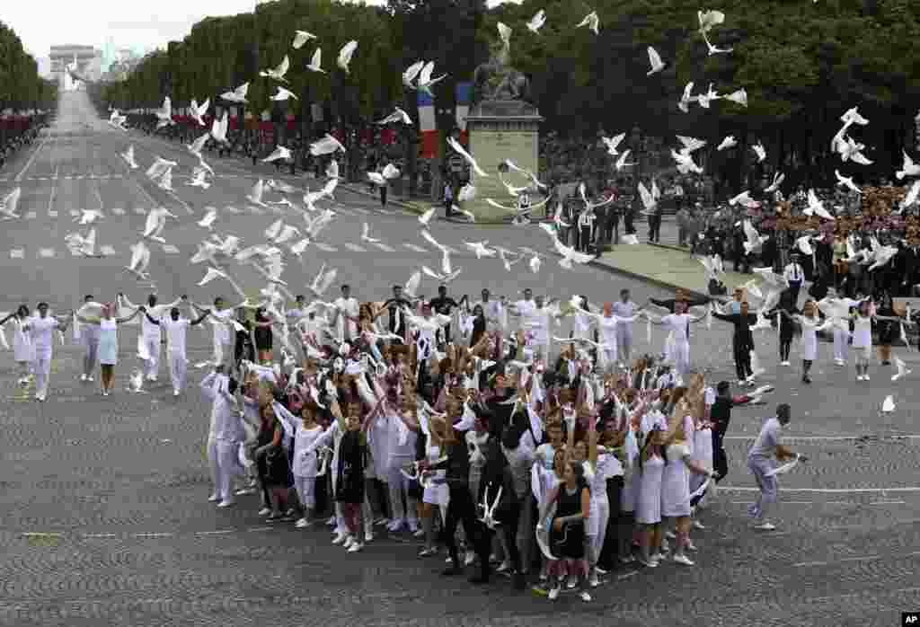 Puluhan merpati dibebaskan setelah parade Hari Bastille di Paris (14/7).&nbsp;(AP/Francois Mori)
