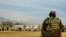 FILE - A Taliban security personnel keeps watch ahead of the court flogging of women and men at a football stadium in Parwan province, Dec. 8, 2022. 