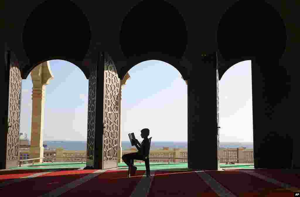 យុវជន​ប៉ាឡេស្ទីន​អាន​គម្ពីរ​កូរ៉ាន់​ នៅ​អំឡុងពេល​ខែ​បុណ្យ​រ៉ាម៉ាដាន (Ramadan) នៅ​វិហារ​ឥស្លាម​តាម​បណ្តោយ​ឆ្នេរ​ខ្សាច់​មួយ​ក្នុង​ក្រុង Gaza City។