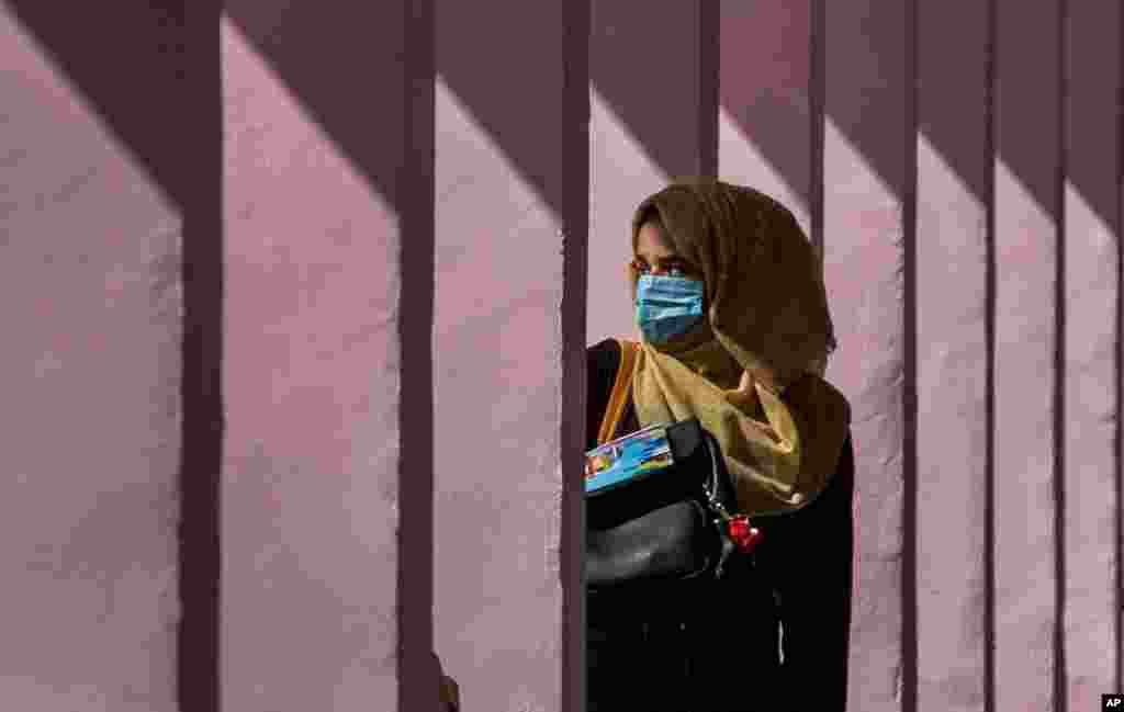 인도령 카슈미르의 스리나가르에서 신종 코로나바이러스 사태로 5개월 만에 문을 연 학교에 마스크를 쓴 학생이 등교하고 있다.