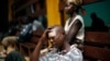 A man wounded in fighting between anti-Balaka and ex-seleka troops sits on the floor in the Community Hospital in Bangui, Central African Republic, Dec. 20, 2013.