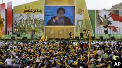 Pendukung pemimpin Hizbullah, Hassan Nasrallah, menonton tayangan pidatonya di Mashghara, Bekaa Valley, Lebanon (25/5). (AP/Hussein Malla)