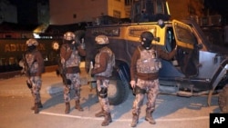 터키 경찰 대테러 부대원들이 지난 5일 새벽 남동부 아디야만에서 진행된 이슬람 수니파 극단주의 무장단체 ISIL 연계세력 체포작전 현장에서 장갑차량 주변에 서있다. 