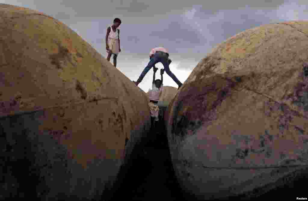 Anak-anak bermain di pinggir sungai Gangga saat mendung di Allahabad, India.