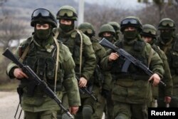 在克里米亚的一个乌克兰军事基地外的武装人员。克里姆林宫后来承认他们是俄罗斯军人。（资料图）