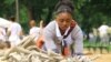 Girl selects crafted "bones" for display at the "One Million Bones" installation on the National Mall, Washington, D.C, June 8, 2013. (Jill Craig/VOA)