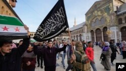 Çekdarên Sûrî alaya Heyat Tahrir El-Sham li Mizgefta El Emewî li Şamê bilind dikinDec. 10, 2024.