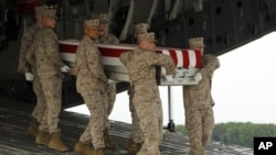 Tim marinir membawa peti jenazah Cpl.Keaton G.Coffey dalam suatu upacara serah terima jenazah di Pangkalan Angkatan Udara Dover, Delaware (26/5). Coffey, salah satu tentara AS yang gugur dalam tugas di Afghanistan.