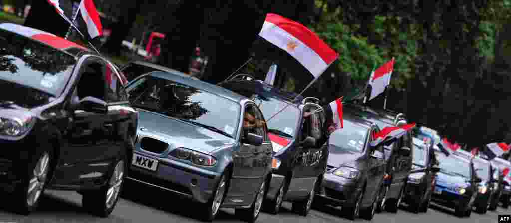 Demonstran pendukung presiden terguling Mohamed Morsi di London melambaikan bendera Mesir dari jendela mobil mereka dalam sebuah protes melawan kekerasan terhadap demonstran di Mesir (17/8).