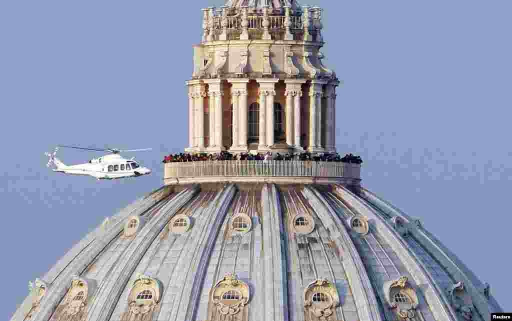 Helikopter yang membawa Paus Benediktus XVI lepas landas dari pusat kota Vatikan menuju rumah kediaman Paus di Kastel Gondolfo. Paus Benediktus mundur dari panggung dunia seusai menyampaikan salam perpisahan terakhirnya kepada para kardinalnya untuk memasuki fase kehidupan yang tersembunyi dari dunia luar di sebuah istana milik negara. 