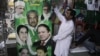 Pakistani vendors fix posters of candidates taking part in the upcoming parliamentary elections in Lahore, Pakistan, April 5, 2013.