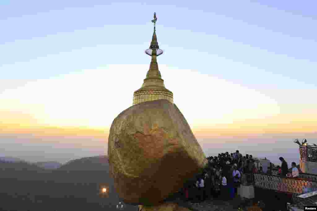 Para penganut Budha menunggu untuk memberikan emas pada Kyaikhtiyo Pagoda, yang juga dikenal dengan Golden Rock Pagoda, di negara bagian Mon, Myanmar, foto tersedia 10 Februari 2014. 