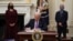 U.S. President Joe Biden signs executive orders as part of the COVID-19 response as U.S. Vice President Kamala Harris, left, and Director of NIAID Anthony Fauci look on in the State Dining Room of the White House in Washington, Jan. 21, 2021. 