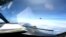 FILE - In this image from video provided by the U.S. Navy, a Chinese J-16 fighter flys aggressively close to a U.S. RC-135 aircraft flying in international airspace over the South China Sea on May 26, 2023. 