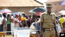 Un policier devant un bureau de vote de Kampala, le 18 février 2016. (AP Photo/Ben Curtis)