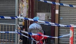 香港當局派駐人員看守封鎖區內的大廈出入口，禁止居民隨便出入。（美國之音 湯惠芸拍攝）