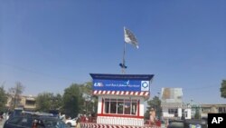 پرچم طالبان در یک میدان اصلی شهر قندوز پس از درگیری طالبان با نیروهای دولتی برافراشته شده است