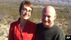 In this photo provided by the office of U.S. Rep. Gabrielle Giffords, Giffords and husband Mark Kelly pose at the Davidson Canyon Gabe Zimmerman Memorial trailhead outside of Tucson, Arizona, January 7, 2012.